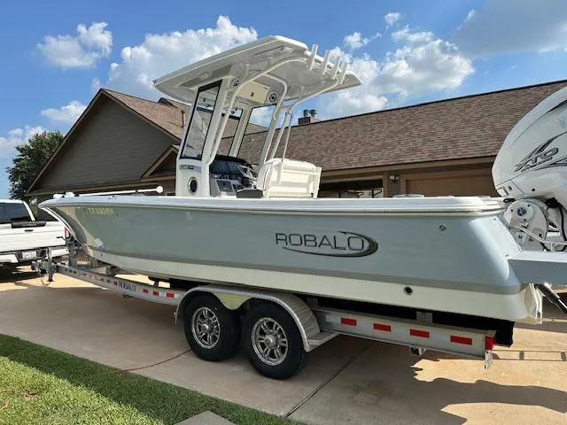 Slide: The Image of 2022 Robalo 266 Cayman boat on a trailer in a driveway. - 3