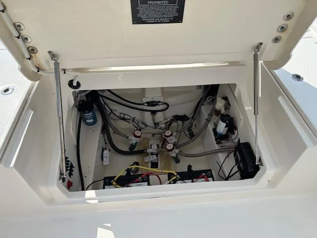 Slide: The Image of 2022 Robalo 266 Cayman boat storage compartment with wiring and battery. - 7