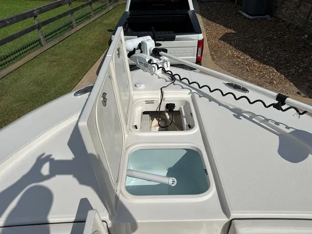 Slide: The Image of 2022 Robalo 266 Cayman boat with open storage compartments and trolling motor. - 9