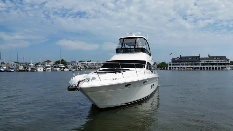 Slide: The Image of 2007 Sea Ray 52 Sedan Bridge yacht on calm waters near a marina. - 13