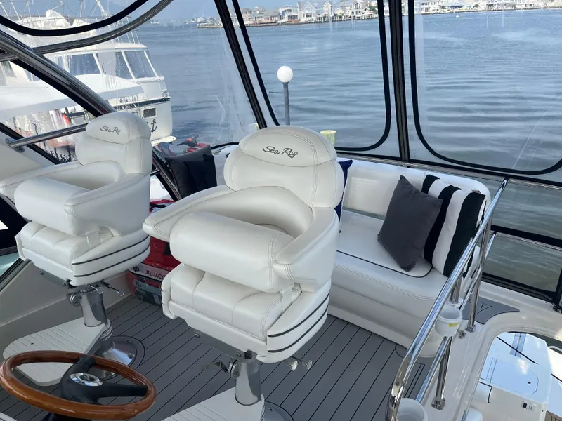 Slide: The Image of 2007 Sea Ray 52 Sedan Bridge yacht interior with white leather seats and waterfront view. - 16