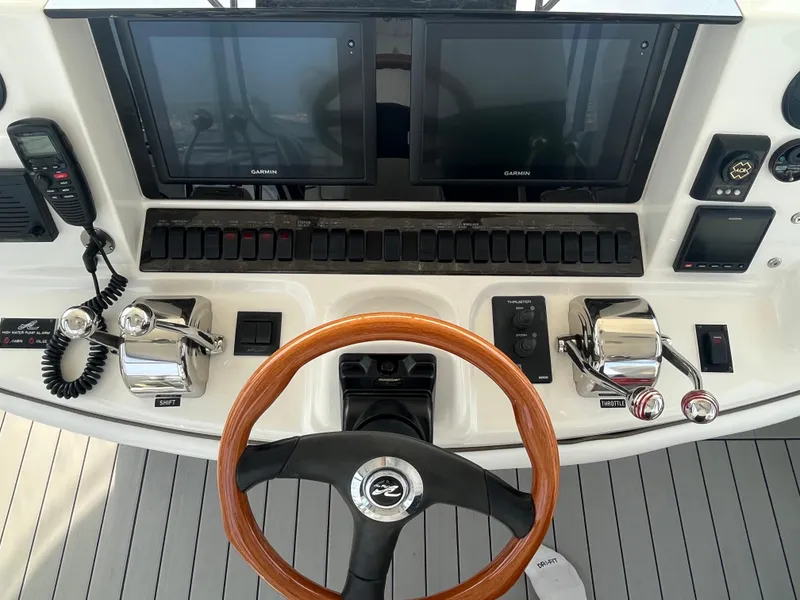 Slide: The Image of 2007 Sea Ray 52 Sedan Bridge helm with dual Garmin displays and wooden steering wheel. - 17