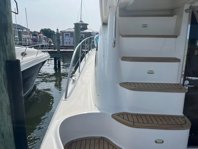 Slide: The Image of 2007 Sea Ray 52 Sedan Bridge yacht docked, showing side deck and stairs. - 28