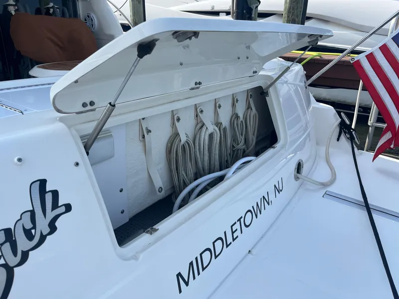 Slide: The Image of 2007 Sea Ray 52 Sedan Bridge boat with open storage compartment and ropes, docked in Middletown, NJ. - 34