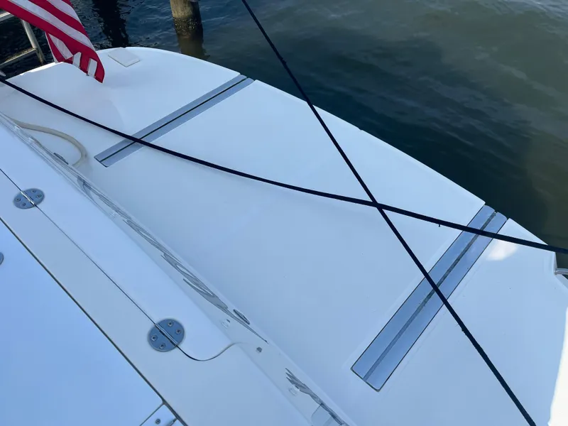 Slide: The Image of 2007 Sea Ray 52 Sedan Bridge swim platform with mooring lines and American flag. - 37