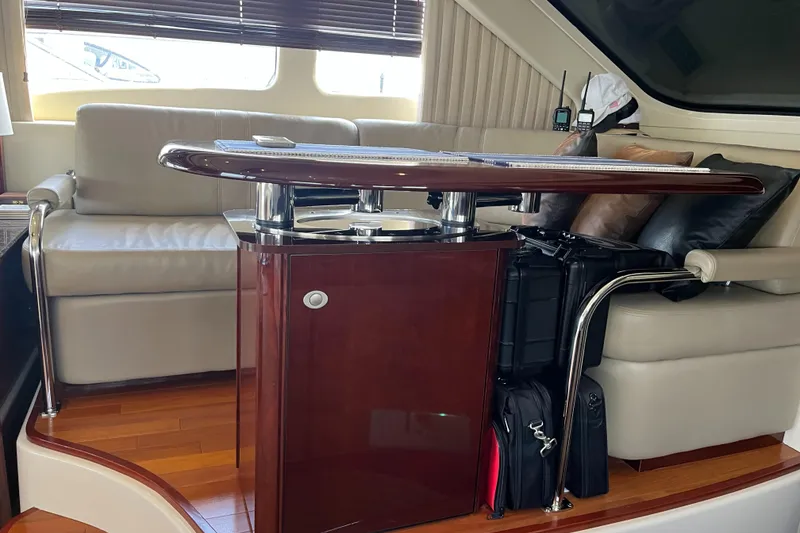 Slide: The Image of Luxurious interior of 2007 Sea Ray 52 Sedan Bridge with leather seating and wooden table. - 49