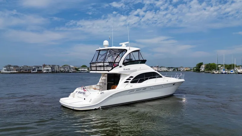 Slide: The Image of 2007 Sea Ray 52 Sedan Bridge yacht on calm waters with a scenic background. - 6