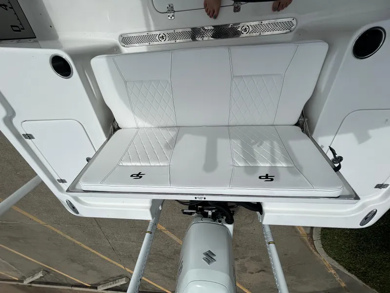 Slide: The Image of 2024 Sea Pro 250 DLX boat with white cushioned seating and Suzuki outboard motor. - 10