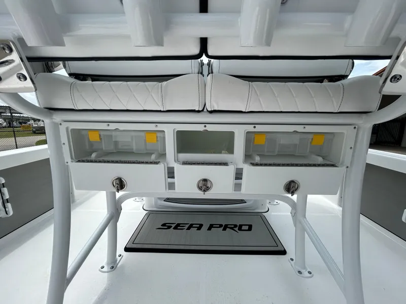 Slide: The Image of 2024 Sea Pro 250 DLX boat interior with storage compartments and cushioned seating. - 16