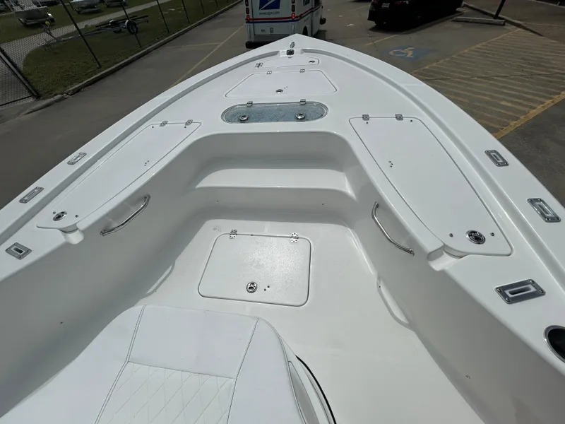 Slide: The Image of 2024 Sea Pro 250 DLX boat bow with storage compartments and seating. - 22