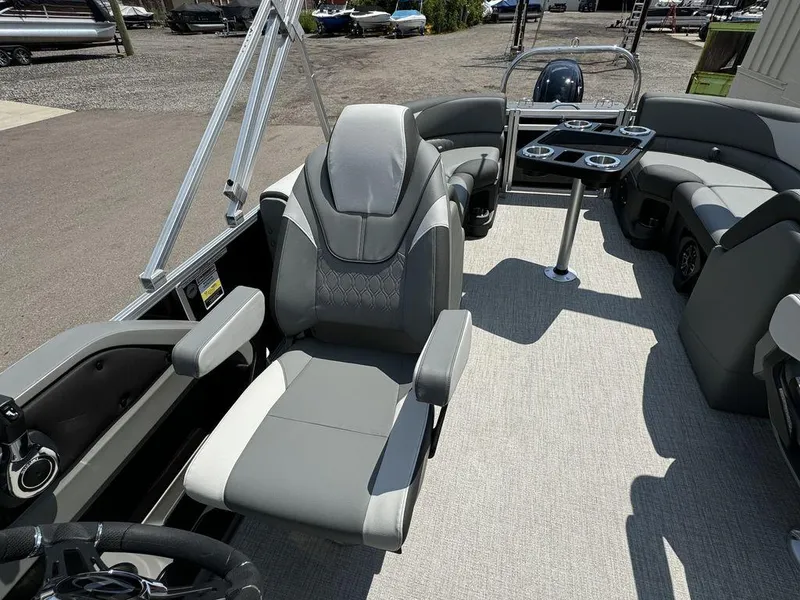 Slide: The Image of 2025 Tahoe LTZ 2385 QL pontoon boat interior with captain's chair and seating area. - 10
