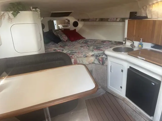 Slide: The Image of Interior cabin of a 1995 Monterey 296 Cruiser with bed, kitchenette, and dining area. - 10