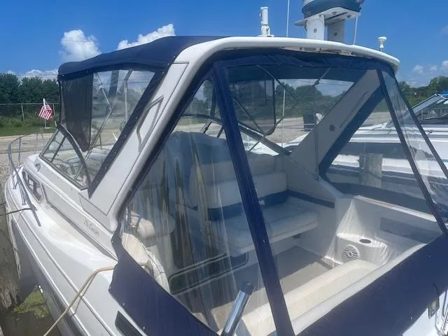 Slide: The Image of 1995 Monterey 296 Cruiser boat with blue canopy docked at marina. - 2