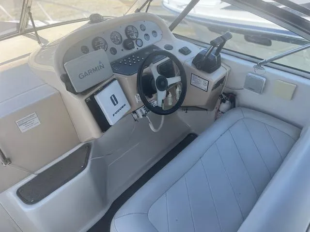 Slide: The Image of 1995 Monterey 296 Cruiser boat cockpit with Garmin navigation system and white seating. - 6