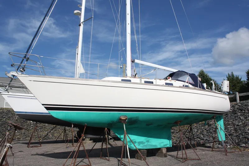 The Image of 1988 Tartan 34-2 Scheel Keel sailboat on stands, clear sky background. - 0