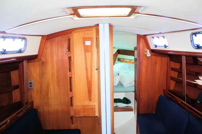 Slide: The Image of Interior of 1988 Tartan 34-2 Scheel Keel sailboat with wooden cabinetry and cozy sleeping area. - 20