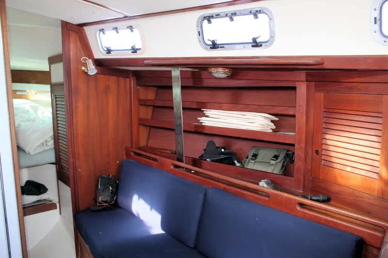 Slide: The Image of Interior of 1988 Tartan 34-2 Scheel Keel sailboat with wooden shelves and blue seating. - 22