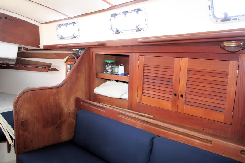 Slide: The Image of 1988 Tartan 34-2 Scheel Keel interior with wooden cabinetry and blue seating. - 23