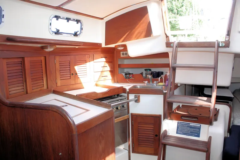 Slide: The Image of 1988 Tartan 34-2 Scheel Keel yacht interior with wooden cabinetry and compact kitchen area. - 25