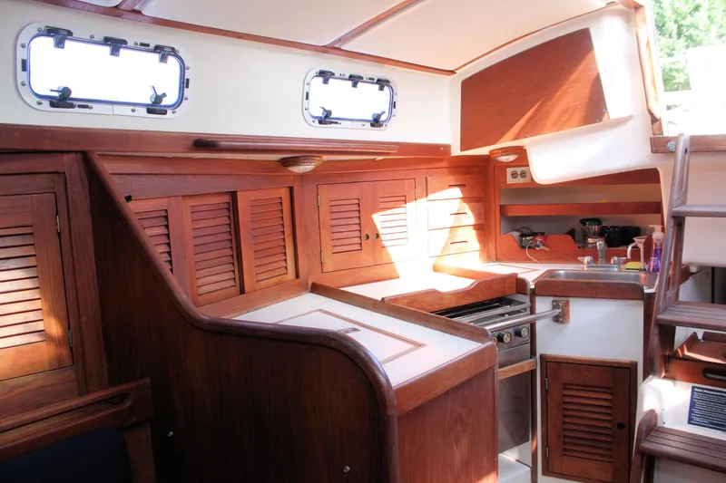 Slide: The Image of Interior of 1988 Tartan 34-2 Scheel Keel sailboat with wooden cabinetry and compact kitchen. - 26