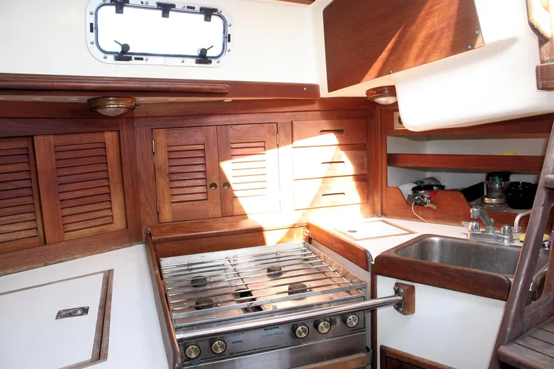 Slide: The Image of 1988 Tartan 34-2 Scheel Keel yacht kitchen with wooden cabinets and stainless steel stove. - 28