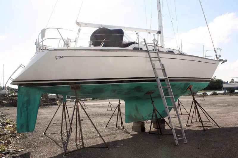 Slide: The Image of 1988 Tartan 34-2 Scheel Keel sailboat on stands with ladder, outdoor setting. - 4