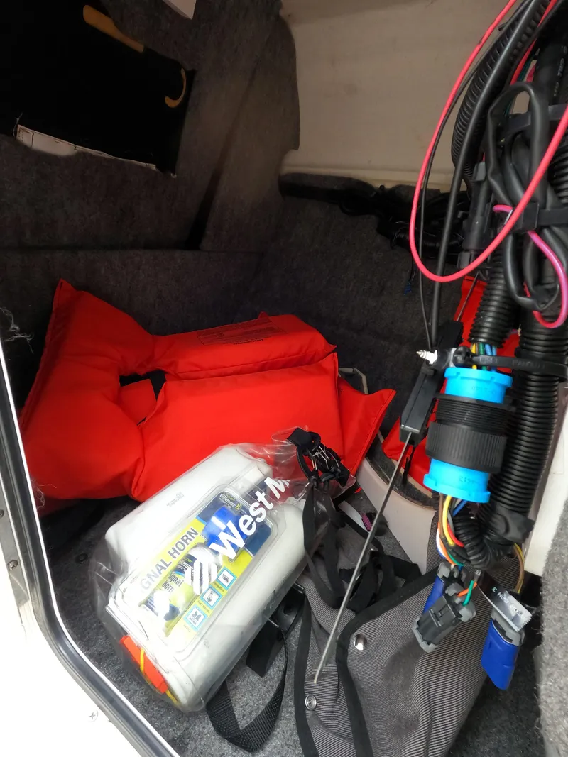 Slide: The Image of Storage compartment of a 2014 Sea Ray 240 Sundeck Outboard with life jackets and equipment. - 10