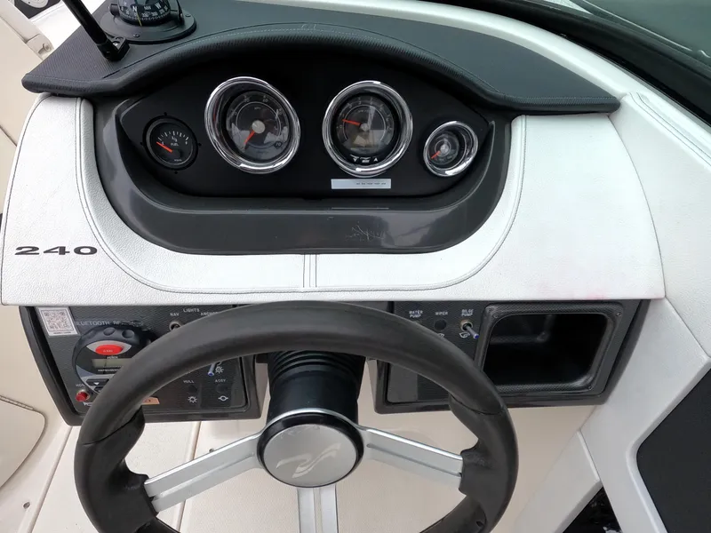 Slide: The Image of 2014 Sea Ray 240 Sundeck Outboard dashboard and steering wheel. - 11