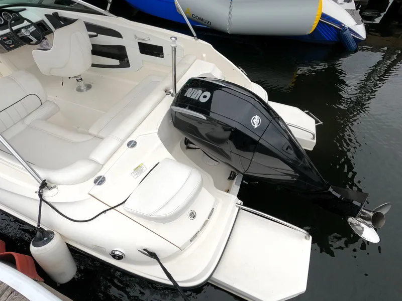 Slide: The Image of 2014 Sea Ray 240 Sundeck Outboard boat with white interior and black outboard motor. - 12