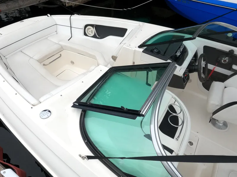 Slide: The Image of 2014 Sea Ray 240 Sundeck Outboard boat interior with white seating and control panel. - 15