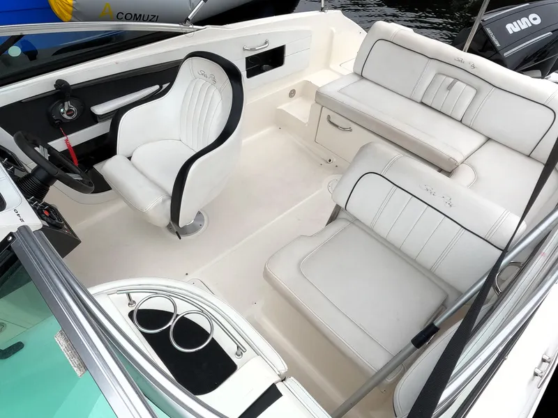Slide: The Image of 2014 Sea Ray 240 Sundeck Outboard interior with white seating and steering console. - 3