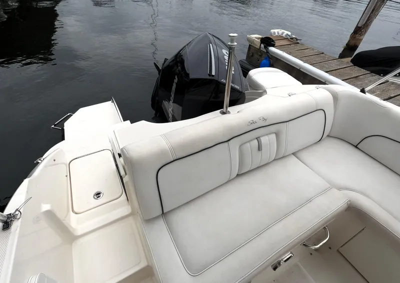 Slide: The Image of 2014 Sea Ray 240 Sundeck Outboard boat with white seating and docked at marina. - 4