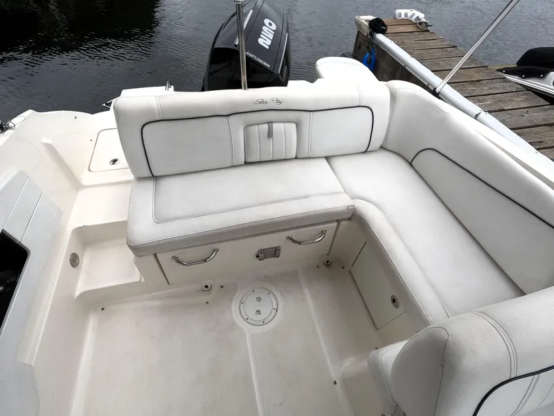 Slide: The Image of 2014 Sea Ray 240 Sundeck Outboard boat with white cushioned seating. - 9
