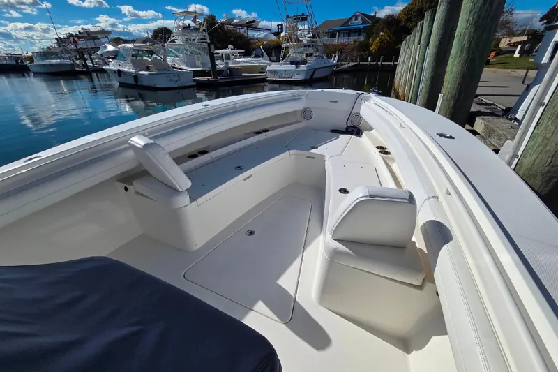 Slide: The Image of 2020 Regulator 25 boat interior with seating, docked at marina under blue sky. - 15