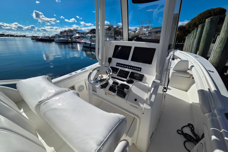 Slide: The Image of 2020 Regulator 25 boat interior with helm, steering wheel, and navigation screens. - 16