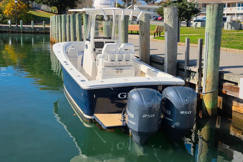 Slide: The Image of 2020 Regulator 25 boat docked at a marina with buildings in the background. - 2