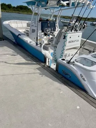 Slide: The Image of 2021 Sea Fox 288 Commander docked, featuring fishing rods and advanced navigation equipment. - 2