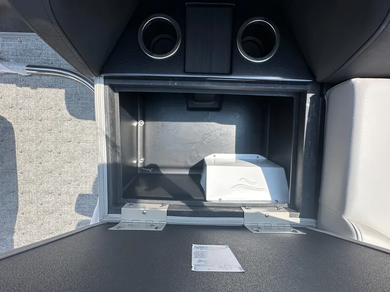 Slide: The Image of Storage compartment of 2025 South Bay 220RSLE boat with cup holders and grey interior. - 10