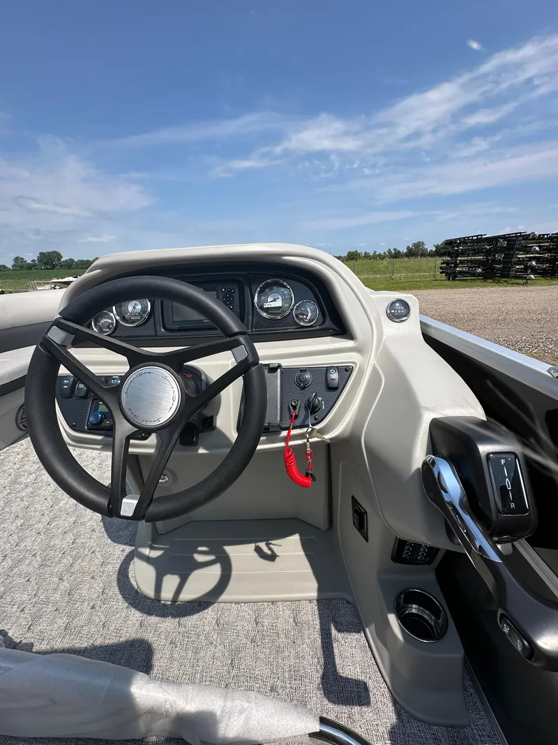 Slide: The Image of 2025 South Bay 220RSLE boat dashboard with steering wheel and controls. - 13