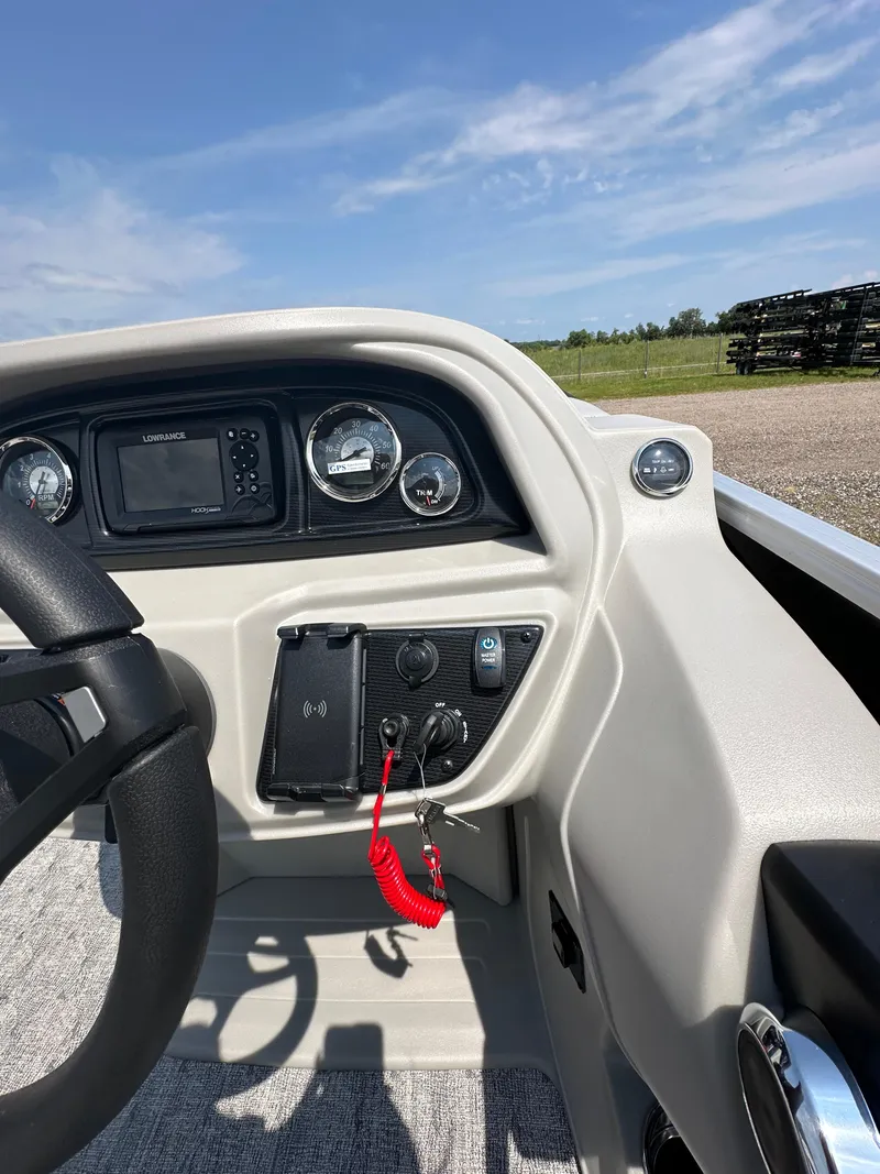 Slide: The Image of 2025 South Bay 220RSLE boat dashboard with steering wheel and control panel. - 14