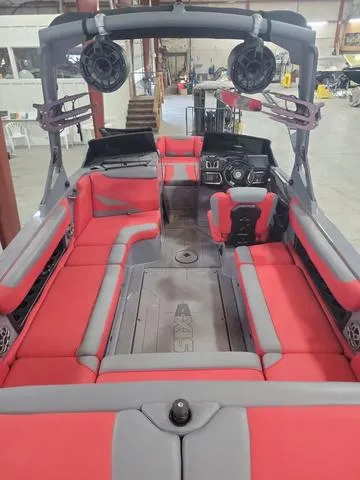 Slide: The Image of 2022 Axis Wake Research T23 boat interior with red and gray seating in a warehouse. - 3