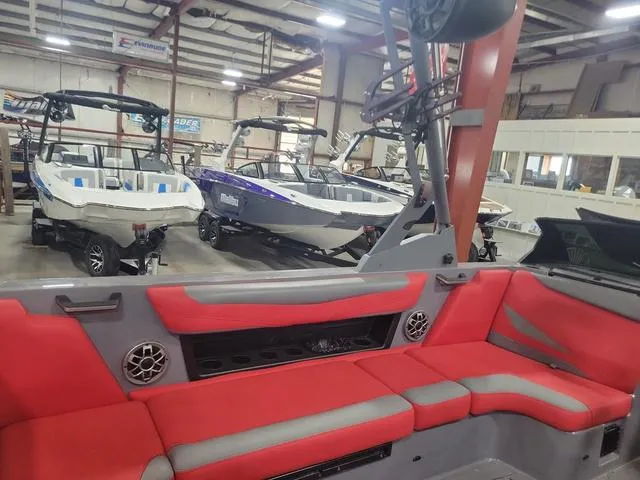 Slide: The Image of 2022 Axis Wake Research T23 boats in showroom with red and gray interior. - 4