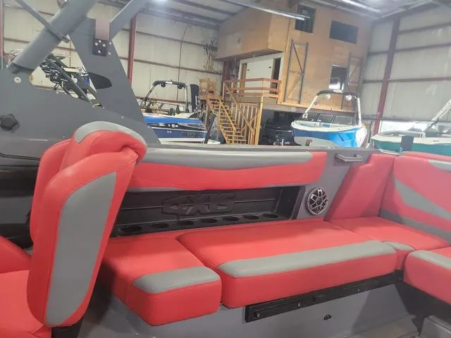 Slide: The Image of 2022 Axis Wake Research T23 boat interior with red and gray seating in a showroom. - 5