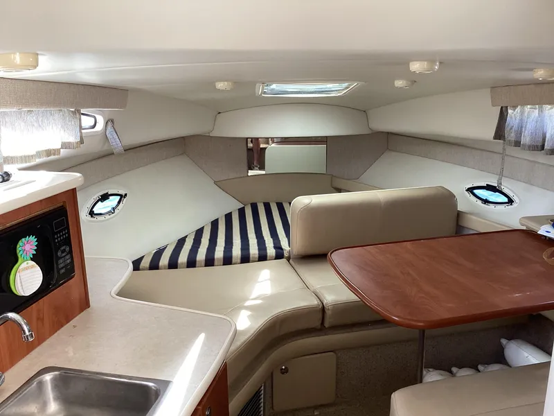 Slide: The Image of Interior of 2004 Bayliner 2655 Ciera with seating, table, and kitchenette. - 18