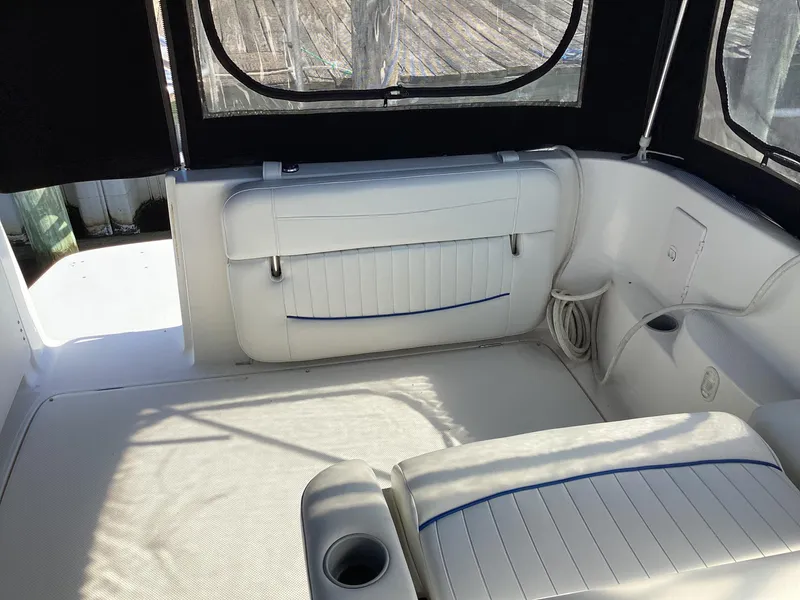 Slide: The Image of Interior seating of 2004 Bayliner 2655 Ciera boat with white upholstery and cup holder. - 6