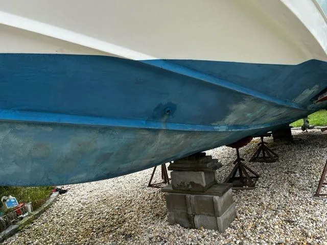 Slide: The Image of 2004 Boston Whaler 320 Outrage boat hull on blocks for maintenance. - 10