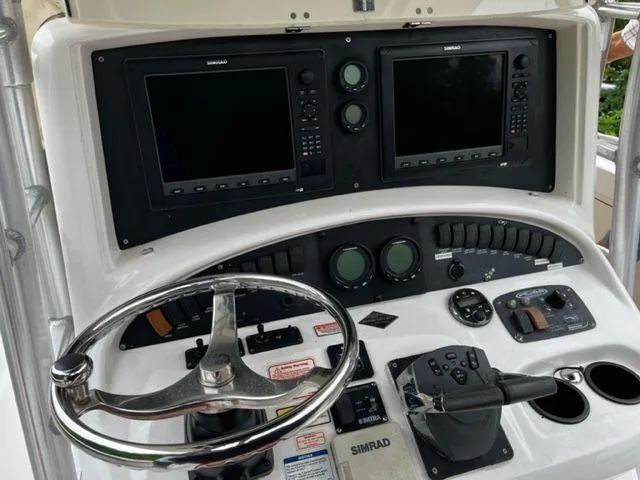 Slide: The Image of Boston Whaler 320 Outrage 2004 helm with dual Simrad displays and steering wheel. - 14