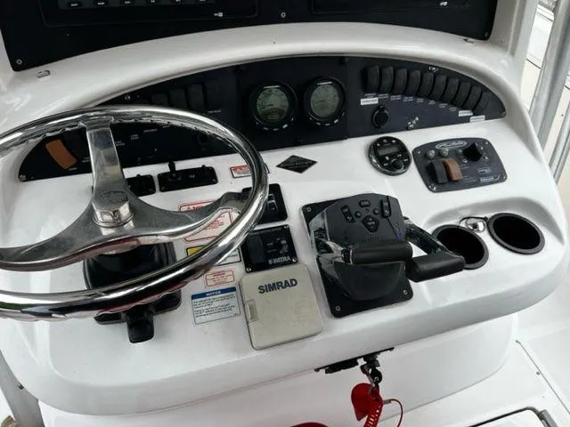 Slide: The Image of Boston Whaler 320 Outrage 2004 boat dashboard with steering wheel and control panel. - 18