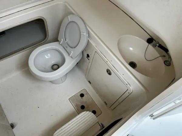 Slide: The Image of 2004 Boston Whaler 320 Outrage boat bathroom with toilet and sink. - 28