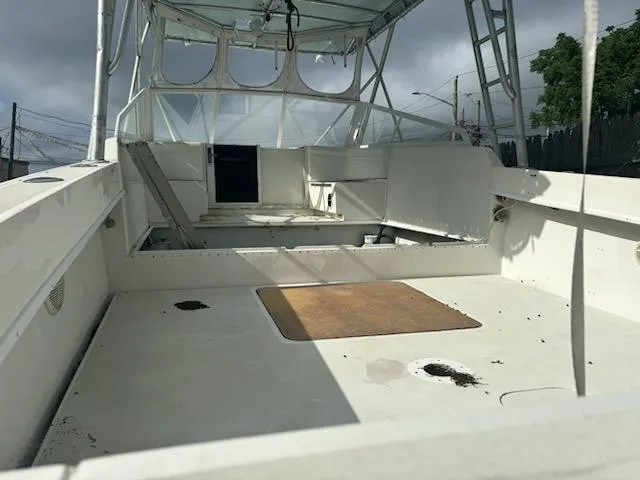 Slide: The Image of 1998 Contender 35 Express boat interior, featuring spacious deck and cabin under cloudy skies. - 4